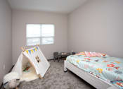 Thumbnail 15 of 37 - A child's bedroom with a teepee tent and a bed with a colorful blanket.