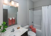Thumbnail 17 of 37 - A bathroom with a white sink, toilet, and shower curtain.