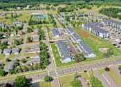 Thumbnail 34 of 37 - A bird's eye view of a residential area with apartment buildings, houses, and a swimming pool.