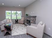 Thumbnail 12 of 37 - A living room with a stone fireplace and a large window.