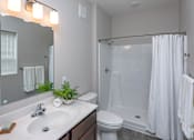 Thumbnail 16 of 37 - A white bathroom with a sink, toilet, and shower.