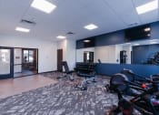 Thumbnail 8 of 29 - a workout room with bikes and chairs and a wall mounted tv