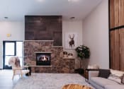 Thumbnail 13 of 29 - a living room with a stone fireplace and a white couch