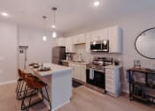 Thumbnail 1 of 29 - a kitchen with white cabinets and a white counter top and a black and white