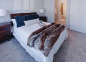 Thumbnail 4 of 29 - a bedroom with a white bed and a furry blanket