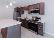 Thumbnail 2 of 29 - a kitchen with wooden cabinets and stainless steel appliances