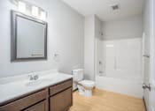Thumbnail 19 of 36 - A white bathroom with a toilet, sink, and mirror.
