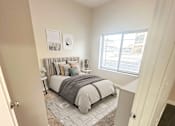 Thumbnail 13 of 36 - A bedroom with a bed, nightstand, and two pictures on the wall.