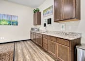 Thumbnail 25 of 36 - A kitchen with wooden cabinets and a marble countertop.