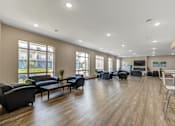 Thumbnail 26 of 36 - A spacious living room with a variety of seating options and a television.
