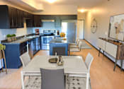 Thumbnail 5 of 36 - A modern kitchen with a dining table and chairs.