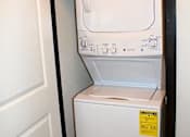 Thumbnail 22 of 36 - A white dishwasher is in a dark room.