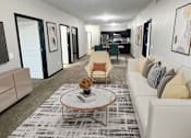 Thumbnail 6 of 36 - A living room with a white couch and a coffee table.