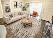Thumbnail 7 of 36 - A living room with a white couch, a coffee table, and a rug.