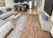 Thumbnail 9 of 36 - A living room with a grey couch and a brown rug.