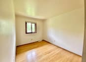 Thumbnail 11 of 11 - A room with a window and wooden floors at Root River Apartments, Greendale, Wisconsin