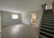 Thumbnail 7 of 11 - A room with a staircase leading to another room at Root River Apartments, Wisconsin 53129