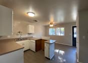 Thumbnail 8 of 11 - A kitchen with white cabinets and a white dishwasher at Root River Apartments, Greendale, WI, 53129