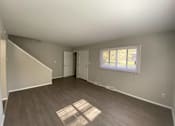 Thumbnail 5 of 11 - A room with a window and a door is shown at Root River Apartments, Greendale