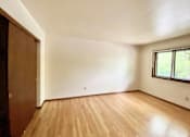 Thumbnail 4 of 11 - A room with wooden flooring and a window at Root River Apartments, Greendale, Wisconsin