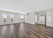 Thumbnail 23 of 24 - A room with wooden floors and three windows.