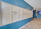 Thumbnail 2 of 23 - A row of mailboxes are lined up against a blue wall.