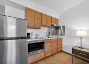 Thumbnail 17 of 23 - A modern kitchen with wooden cabinets and stainless steel appliances.