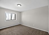 Thumbnail 9 of 32 - A room with a window and carpeted floor.