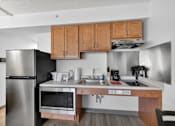 Thumbnail 22 of 23 - A kitchen with a stainless steel refrigerator, microwave, and oven.