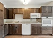 Thumbnail 4 of 66 - A kitchen with brown cabinets and a white dishwasher.