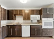 Thumbnail 25 of 66 - A kitchen with brown cabinets and a white dishwasher.