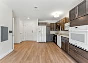 Thumbnail 5 of 66 - A kitchen with white appliances and wooden floors.