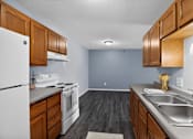 Thumbnail 17 of 32 - A kitchen with white appliances and wooden cabinets.