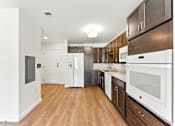 Thumbnail 17 of 66 - A modern kitchen with white appliances and wood floors.