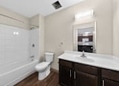 Thumbnail 12 of 46 - A white toilet sits next to a white sink in a bathroom.