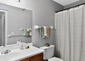 Thumbnail 10 of 32 - A white bathroom with a toilet, sink, and shower.
