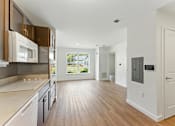 Thumbnail 23 of 66 - A modern kitchen with wooden floors and white walls.