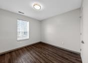 Thumbnail 10 of 46 - A room with a window and a wooden floor.
