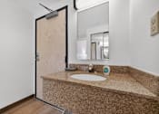 Thumbnail 11 of 23 - A bathroom with a sink and a mirror.