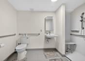 Thumbnail 23 of 23 - A white toilet sits next to a white sink in a bathroom.