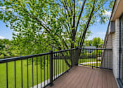 Thumbnail 12 of 32 - A balcony with a black railing and a wooden floor.