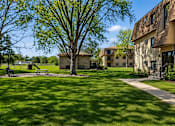 Thumbnail 27 of 32 - A tree in a grassy area in front of a building.