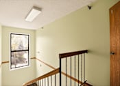 Thumbnail 22 of 32 - A room with a window and a staircase.