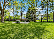 Thumbnail 29 of 32 - A park with a picnic table surrounded by trees.