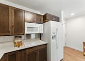 Thumbnail 35 of 66 - A kitchen with brown cabinets and a white fridge.
