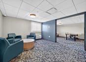 Thumbnail 9 of 23 - A conference room with a carpeted floor and a round table.