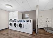 Thumbnail 7 of 23 - A row of washing machines in a laundromat.