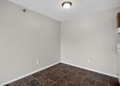 Thumbnail 5 of 32 - A room with a brown tile floor and white walls.