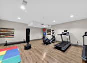 Thumbnail 18 of 46 - A room with a treadmill, a stationary bike, a rowing machine, and a speaker.