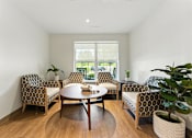 Thumbnail 64 of 66 - A living room with a table and chairs.